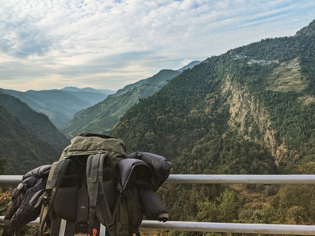Backpack on a rail with a valley view.