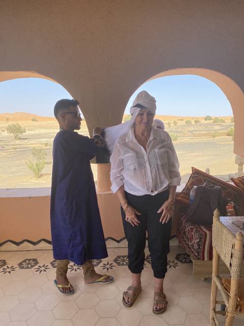 A couple of people standing on a terrace overlooking the desert.