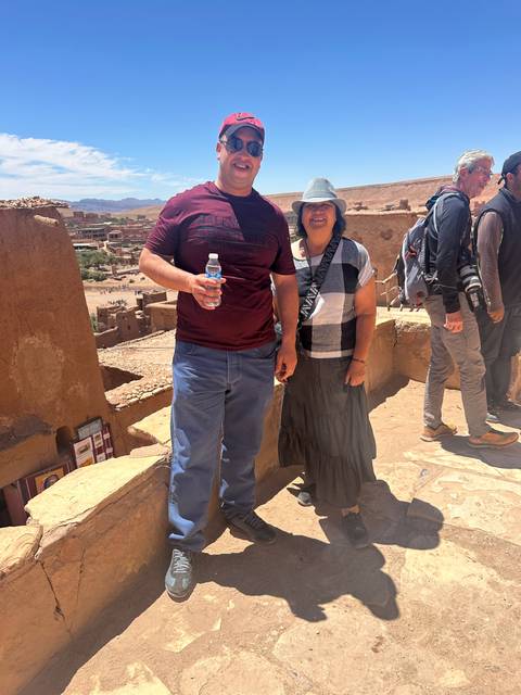 Couple standing on a terrace with a scenic background.