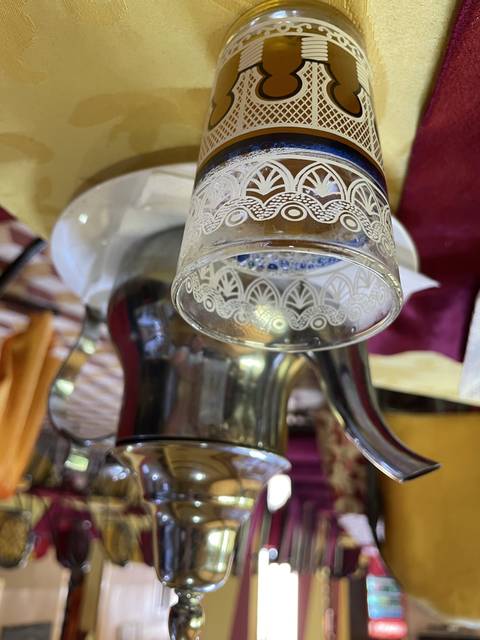       Moroccan tea served in a traditional glass with a teapot.
  