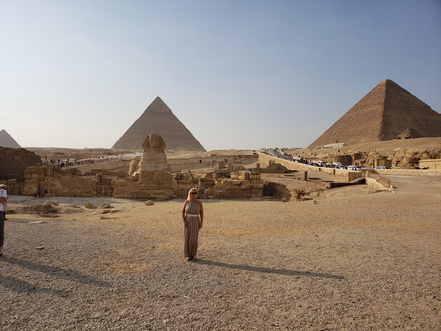 Pyramids and Sphinx with a person posing in the foreground.