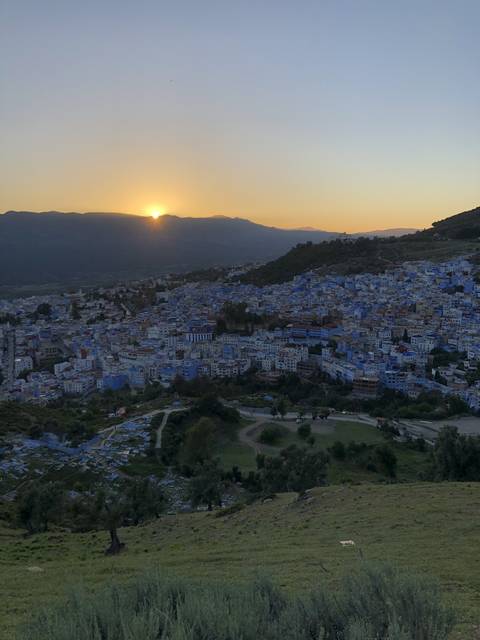       Aerial view of a city with a sunset in the background.
  