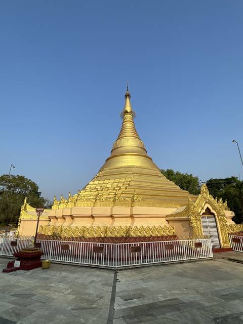 A golden stupa under a clear blue sky.