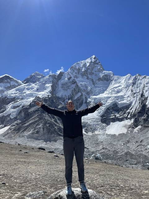       A person posing with majestic snow-covered mountains.
  
