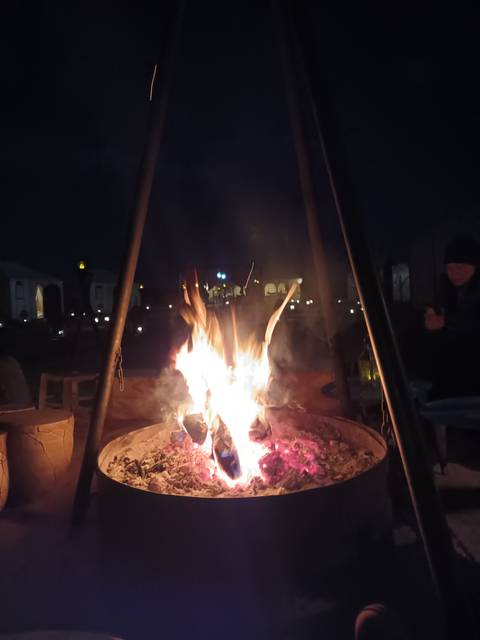 Campfire on sand with chains and night sky.