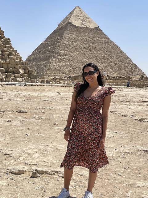 Person smiling in front of the Pyramid of Giza.