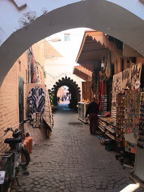       An alleyway with shops and archways.
  