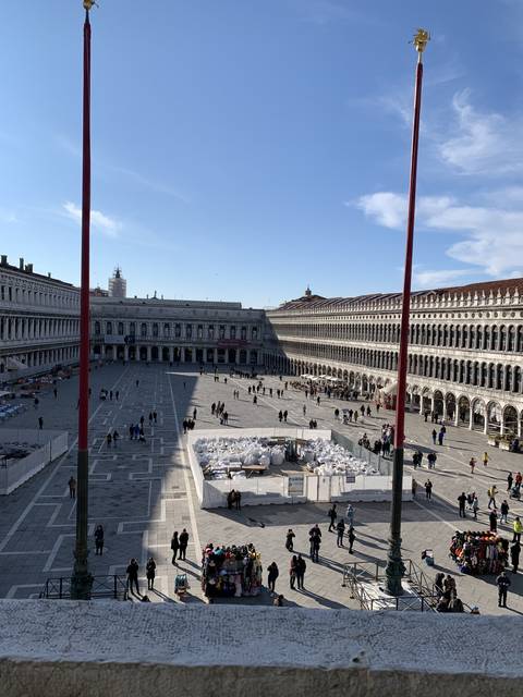       Wide plaza with numerous pedestrians in a historical city.
  