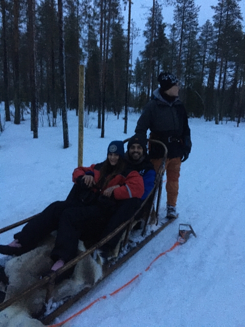 Group of people on a sleigh ride in a snowy forest.