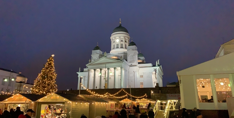 Christmas market with a cathedral lit up at night.