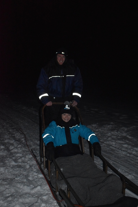 People in a dog sled under low lighting.