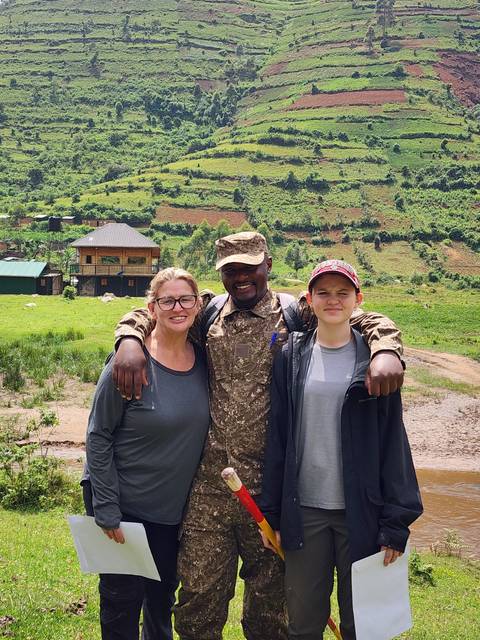       Three people posing with arms around each other.
  