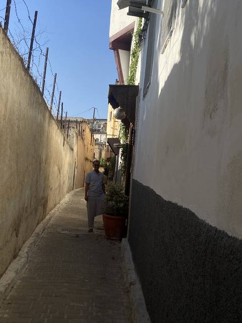       Narrow alleyway with a person walking.
  