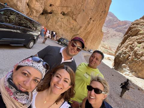       Group of people posing in a desert canyon.
  