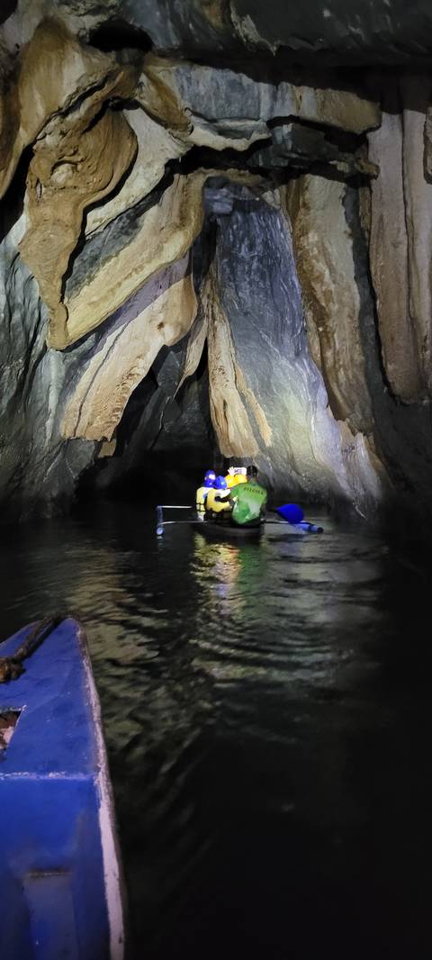       Inside a cave with a rough stone wall and dim lighting.
  