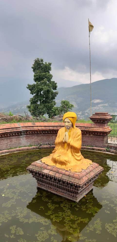       Statue of a monk in a pond.
  