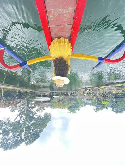Person sitting on a boat looking at the river.