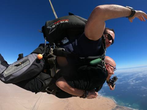      Skydivers in freefall against a clear sky.
  