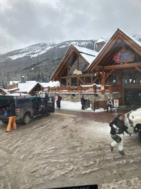       Wooden structure with cars parked in snow.
  