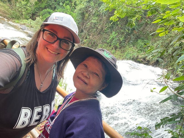       Two people posing in front of a river with greenery.
  