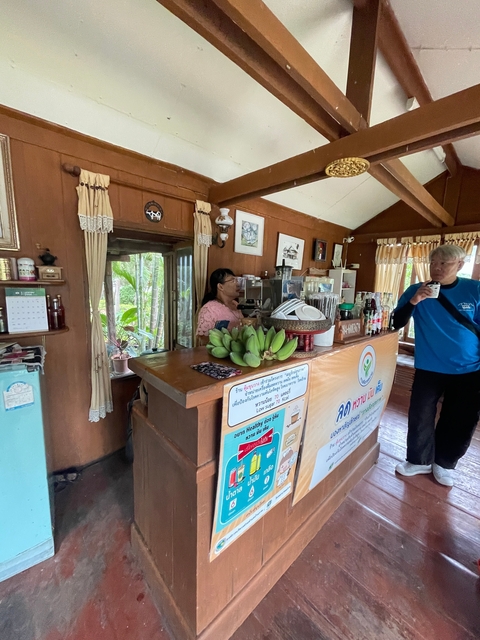       Indoor coffee shop with wooden decor and bananas on display.
  