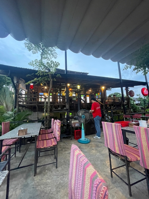       Restaurant with outdoor seating and colorful lights.
  