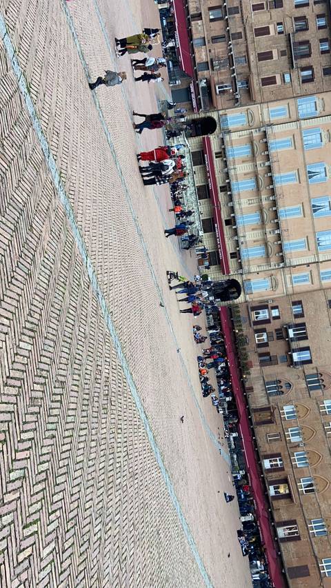 People gathered in a large plaza with historic buildings.
