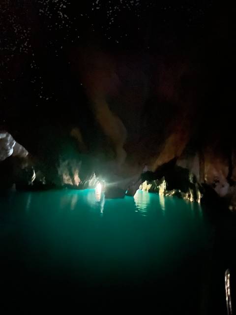       A night scene of a dark cave with water.
  