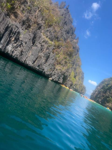       Jagged cliffs with a body of water in the foreground.
  