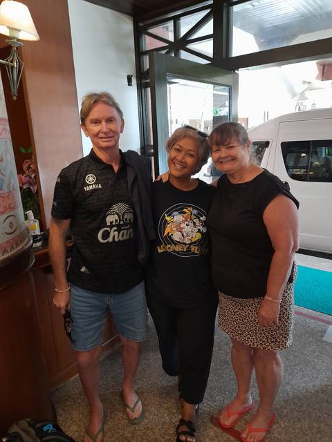 Three people posing indoors, smiling at the camera.