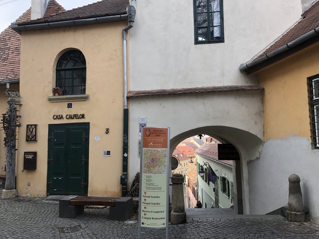 Street view featuring a historical building and an archway.