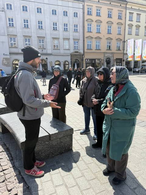       Group of people interacting in a city square.
  