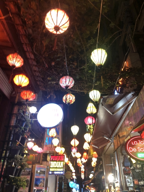 Hanging decorative lanterns illuminating a night market or festival setting.