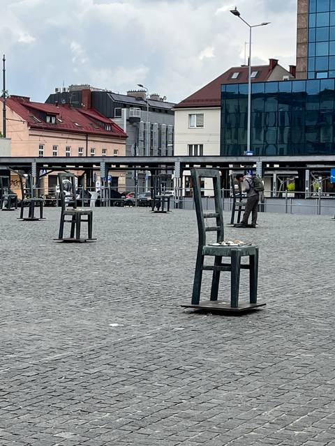       City square with chairs and urban buildings.
  