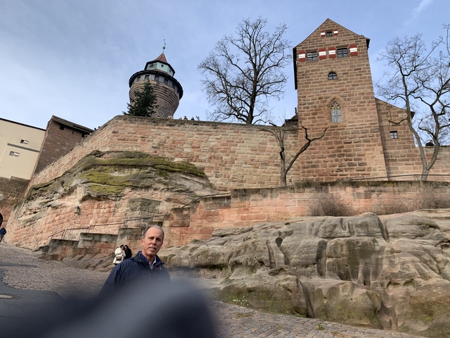 Medieval castle with a watchtower and tourists.