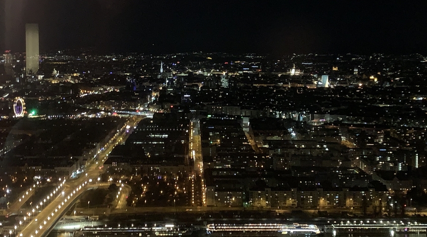 Nighttime aerial view of a city with illuminated streets and buildings.
