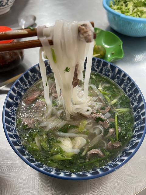       Bowl of noodle soup with chopsticks.
  