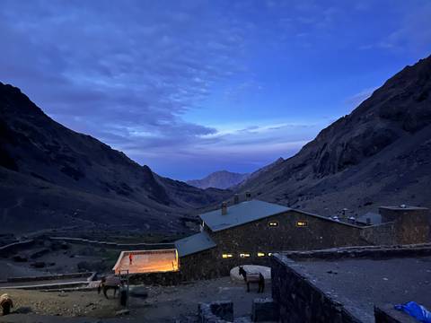 Twilight view of a mountain lodge in a valley.