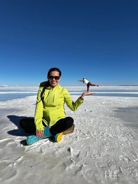 Person at Uyuni Salt Flats performing a perspective trick.