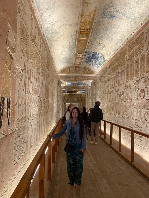 Tourists exploring a hallway with ancient Egyptian hieroglyphs.