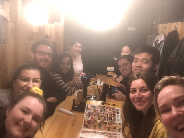 Blurry group of people dining inside a restaurant.