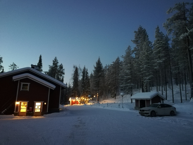 Winter landscape with a small house and snow-covered trees.