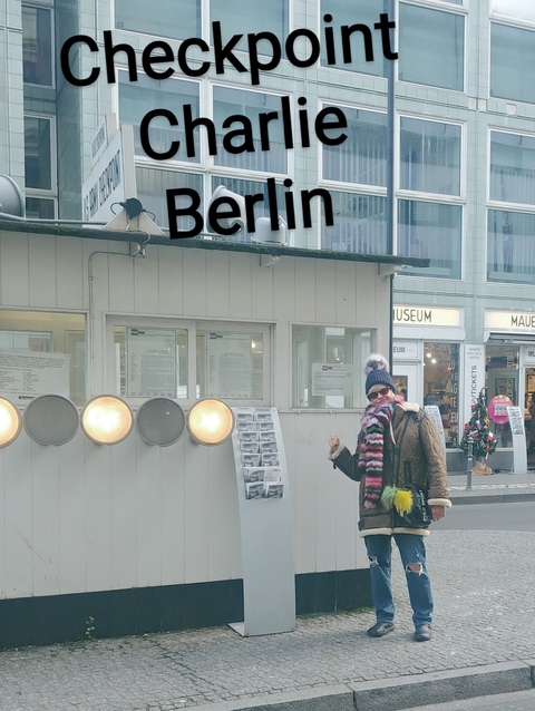 Person in colorful clothes standing in front of checkpoint sign