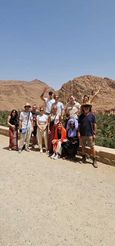       Group photo with a desert mountain backdrop.
  