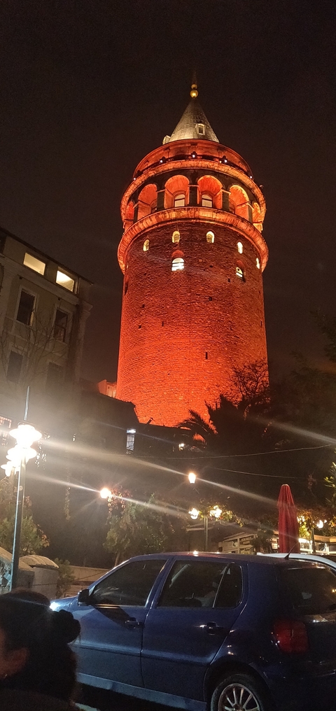       Night view of a tall tower with red lighting.
  