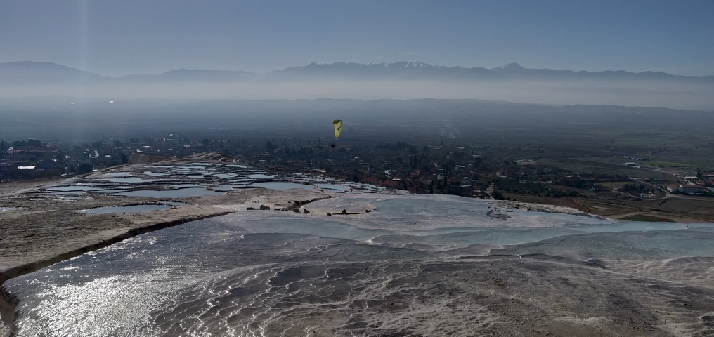 Terraced hot springs of Pamukkale with view of the valley.