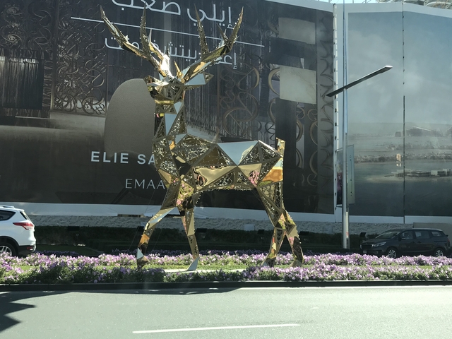 Gold sculpture of a deer on a roundabout.
