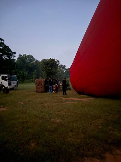 A person beside a large hot air balloon on the ground.