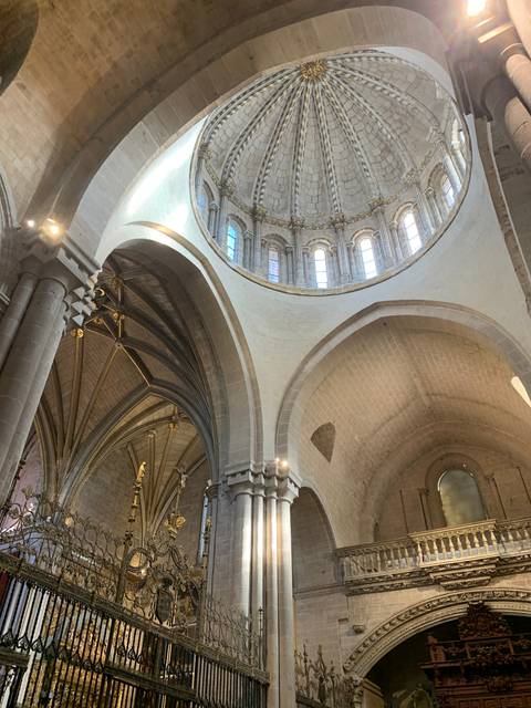       Intricate stone arches and windows of a cathedral interior.
  