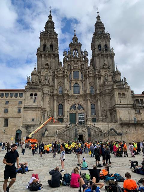       Large cathedral facade with people gathered in front.
  